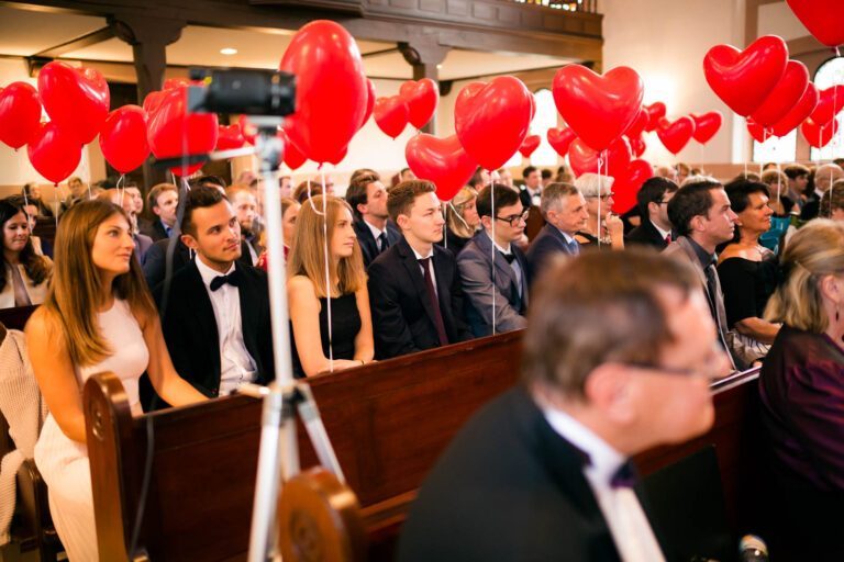 Liebevolle Details der kirchlichen Zeremonie: Ein Meer aus roten Luftballons und emotionale Augenblicke.