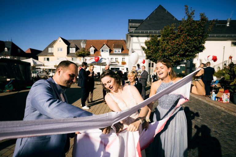 Glückliche Begleitung: Das Brautpaar wird von glücklichen Begleitern umgeben beim Auszug aus dem Standesamt in Usingen auf dem Weg zur Tanzschule Taktgefühl.