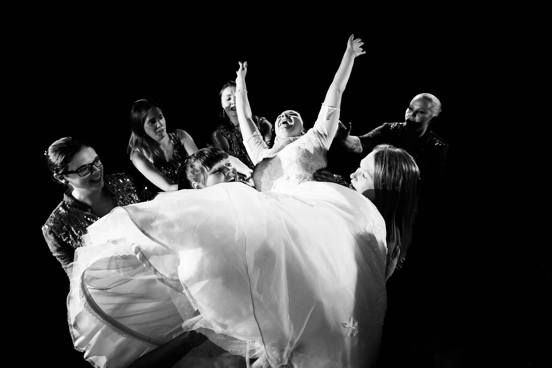 Braut wird in die Luft geworfen und dabei vom Hochzeitsfotografen fotografiert