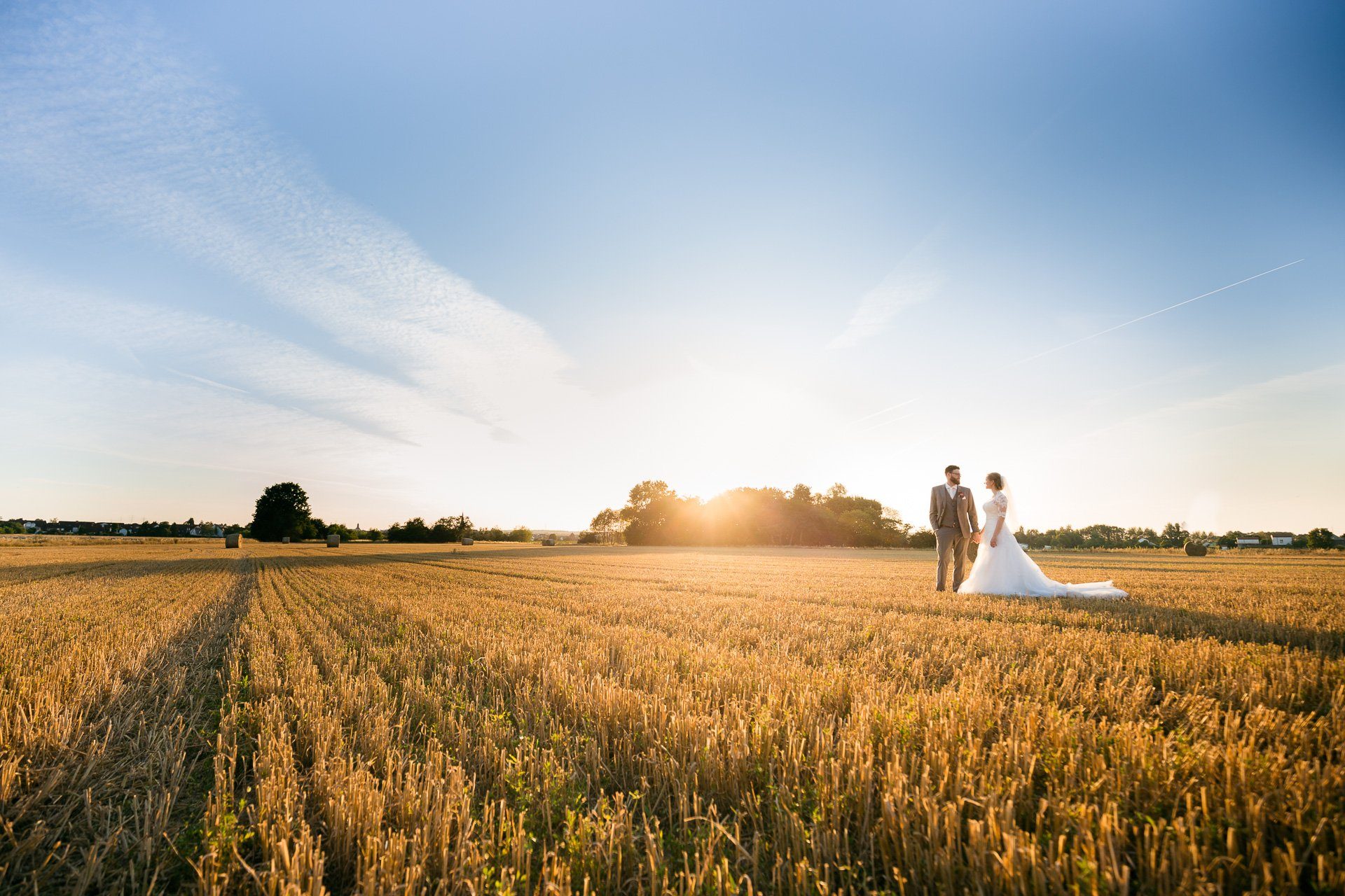 Hochzeitsfotograf Lüneburger Heide. Brautpaar in der Abendsonne auf einem Feld